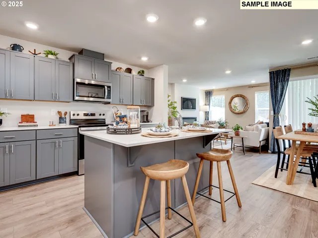a kitchen with stainless steel appliances granite countertop a table chairs sink and cabinets