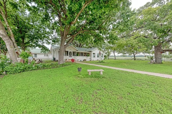 a house view with garden space and trees