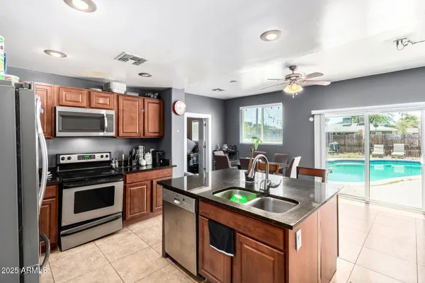 a kitchen with stainless steel appliances granite countertop a refrigerator and stove