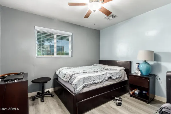 a bed room with a bed mirror and a chandelier