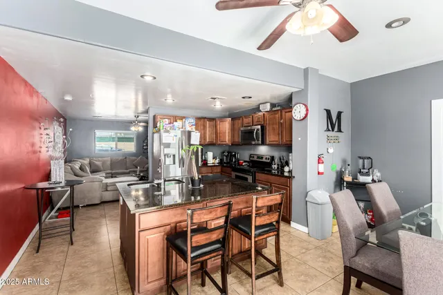 a kitchen with kitchen island granite countertop a sink cabinets and stainless steel appliances