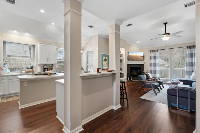 a living room with stainless steel appliances kitchen island granite countertop furniture and a fireplace