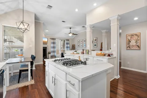 a kitchen that has a stove a table and chairs in it