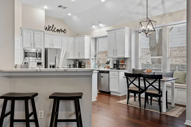 a kitchen with a table chairs stove and microwave
