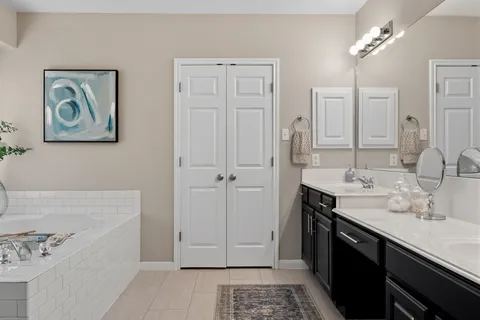 a spacious bathroom with a tub sink and mirror