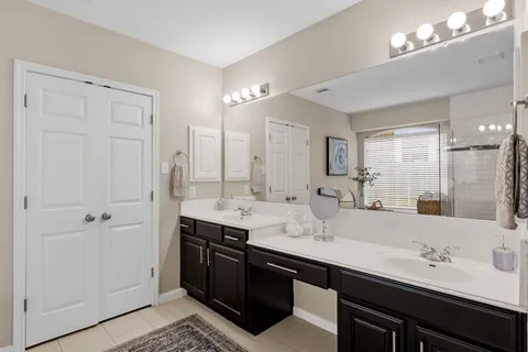 a bathroom with double vanity sinks and a mirror