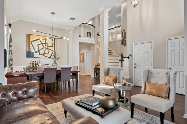 a living room with furniture kitchen view and a chandelier