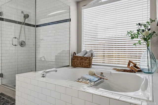 a bathroom with a granite countertop sink and a bathtub