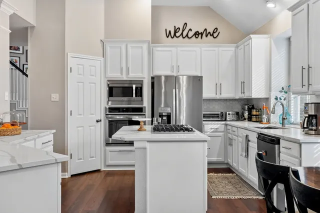 a kitchen with stainless steel appliances a stove refrigerator sink and cabinets