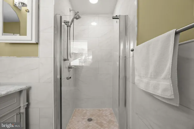 a bathroom with a glass door shower and a sink