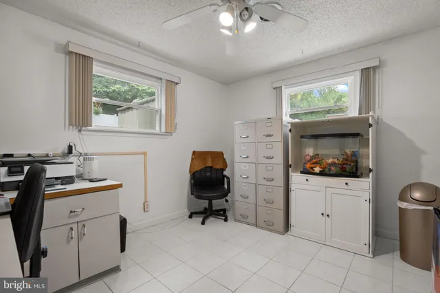 a view of a workspace with furniture and a window