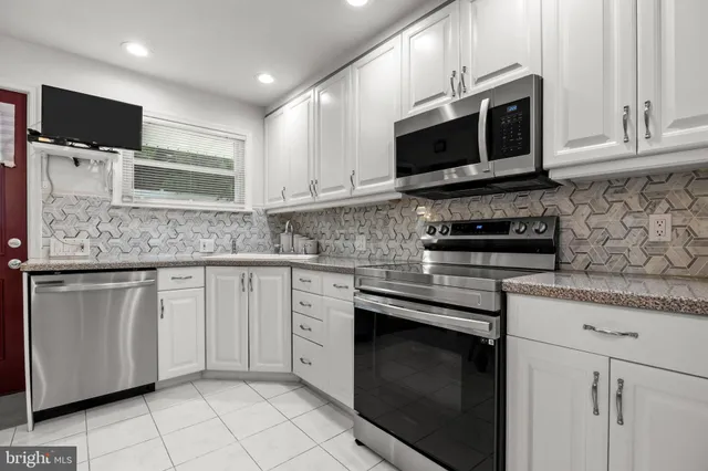 a kitchen with stainless steel appliances granite countertop a stove microwave and cabinets