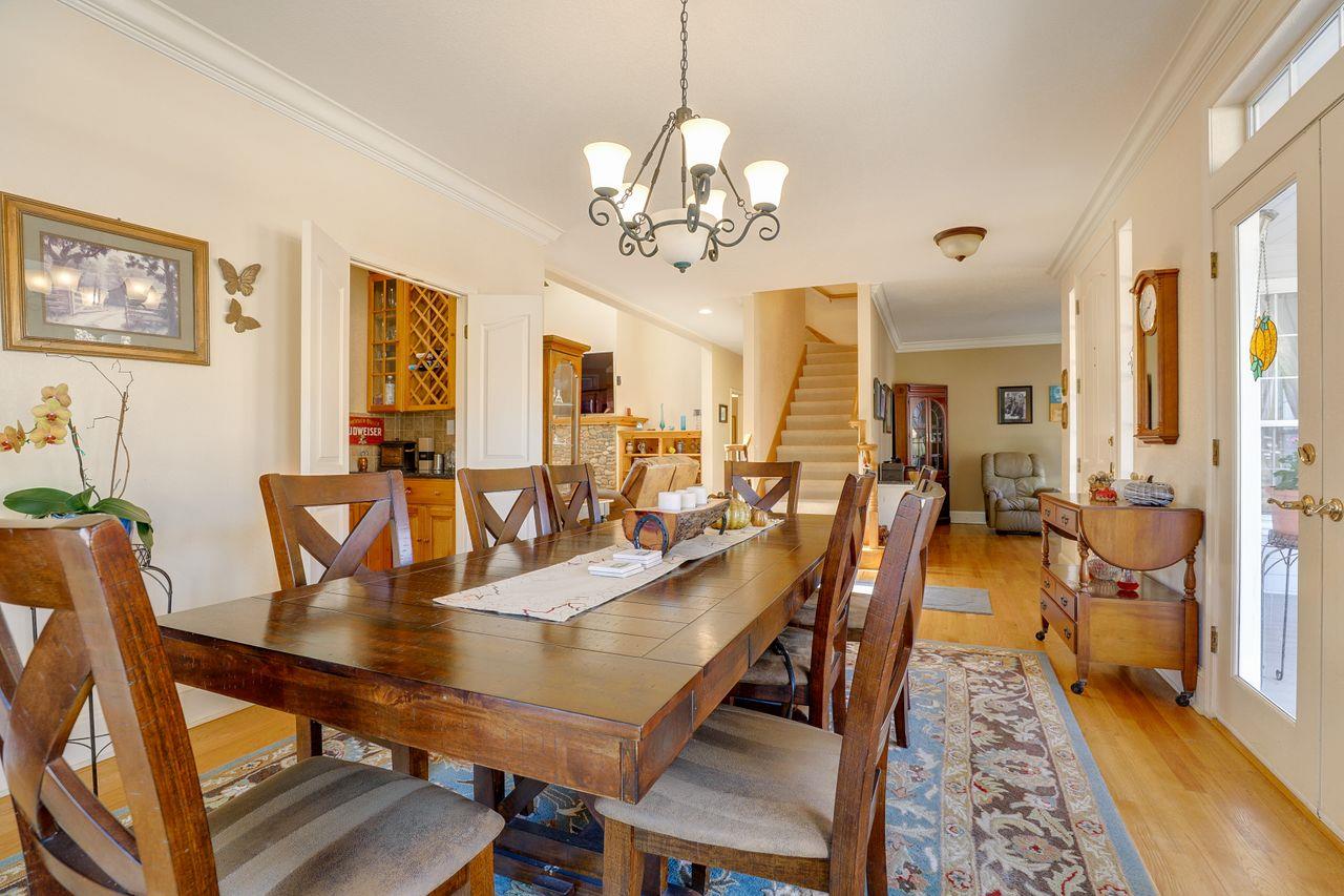 5560 Diablo Hills Road Tres Pinos, CA 95075 - Photo 9 of 46 a dining room with wooden floor a chandelier a wooden table and chairs