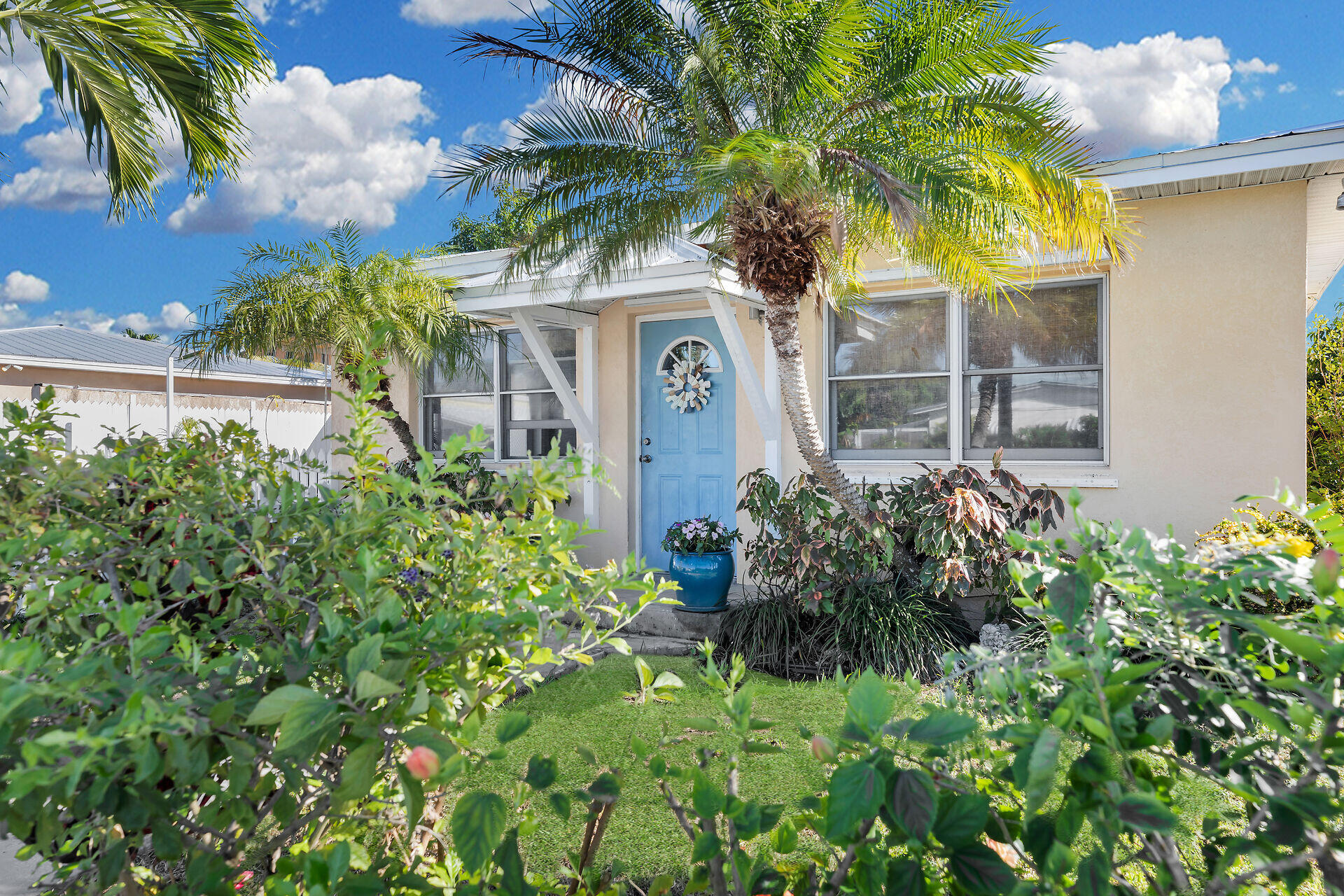 a front view of a house with a yard and potted plants