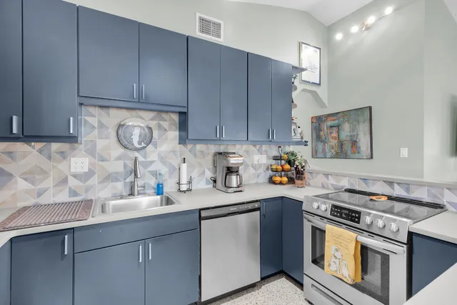 a kitchen with stainless steel appliances granite countertop a sink stove and cabinets