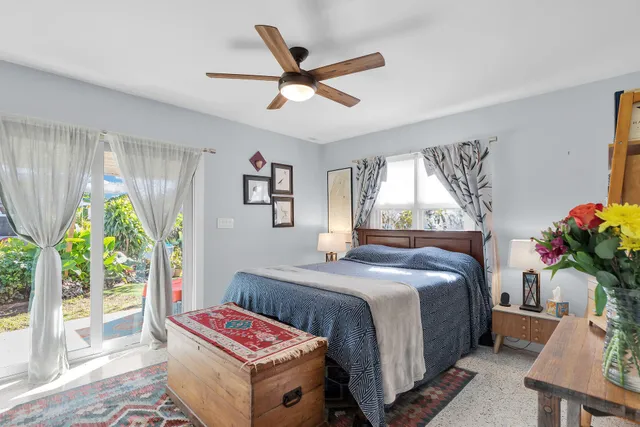 a bedroom with a bed a chandelier and a window