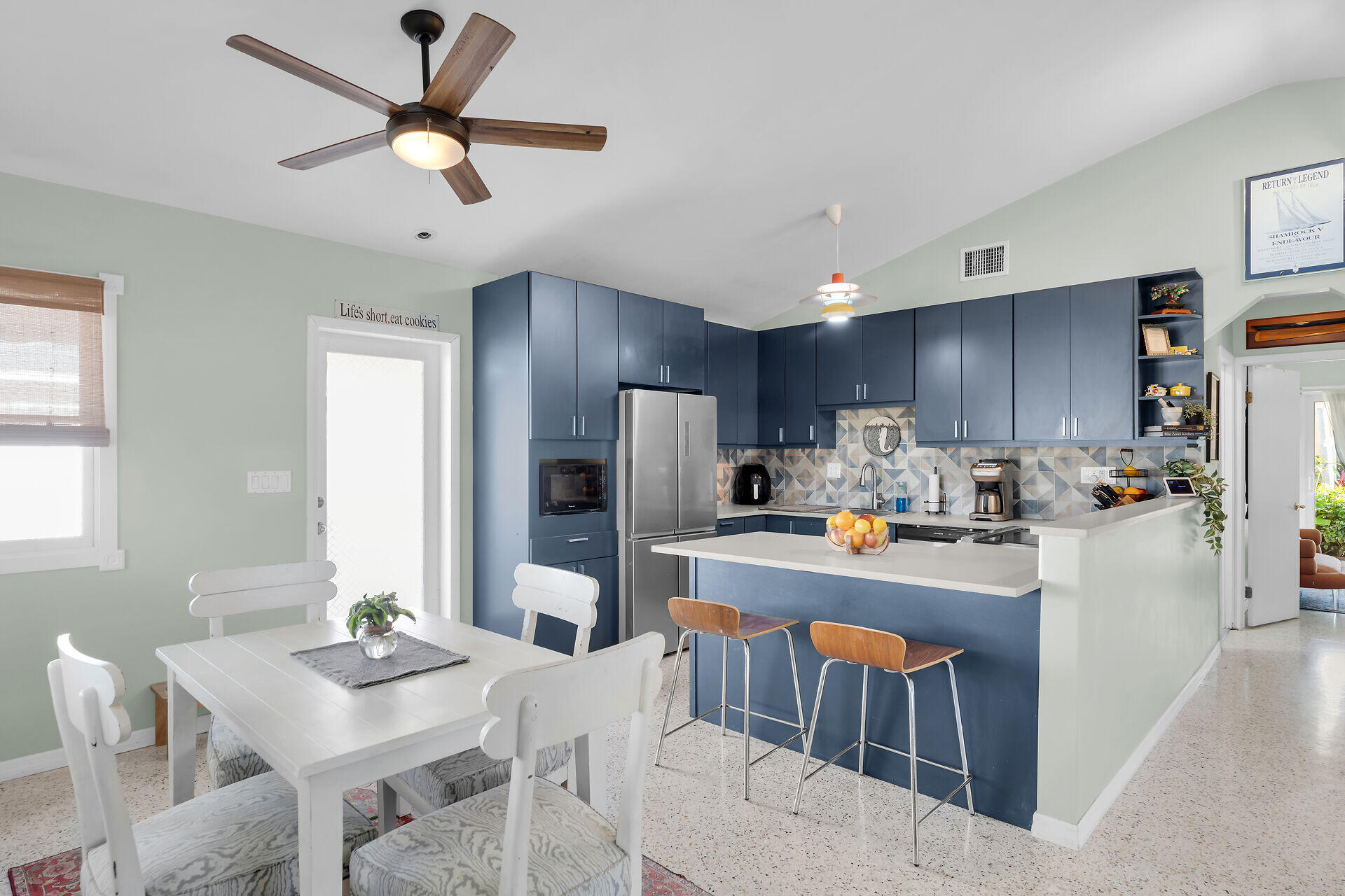 1417 8th Street Key West, FL 33040 - Photo 9 of 44 a kitchen with stainless steel appliances granite countertop a refrigerator a stove a sink a dining table and chairs with wooden floor