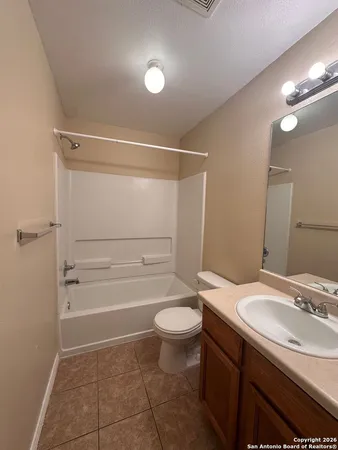 a bathroom with a granite countertop sink a toilet and shower