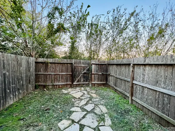 a backyard of a house with lots of green space and bench