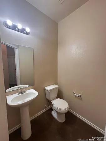 a bathroom with a toilet sink and mirror