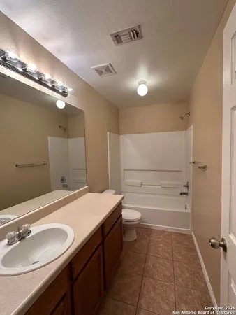 a bathroom with a sink a toilet a mirror and shower