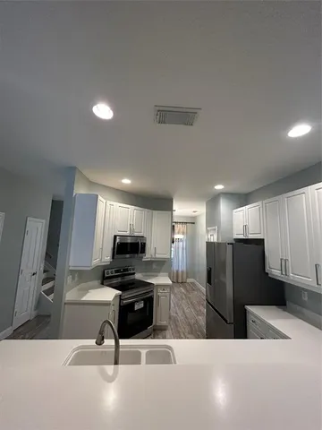 a kitchen with stainless steel appliances a refrigerator sink microwave and cabinets