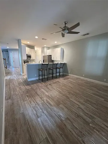 a view of a kitchen with a sink and wooden floor