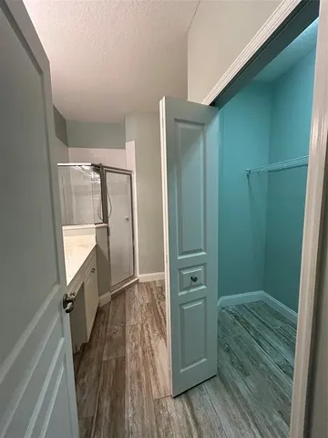 a bathroom with a glass door shower a sink and a toilet