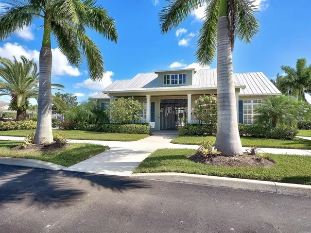 a front view of a house with a yard and palm trees