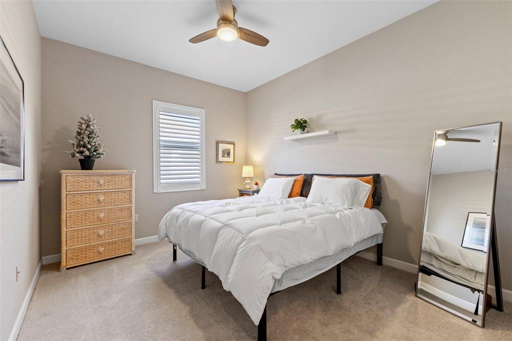 6840 Coyote Ridge Court Bradenton, FL 34201 - Photo 25 of 39 a bedroom with a bed and a chandelier