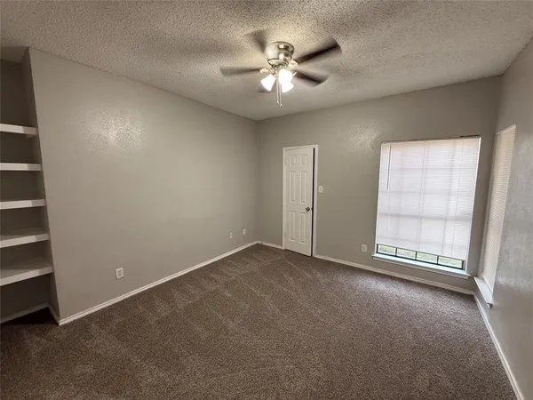 an empty room with windows and closet