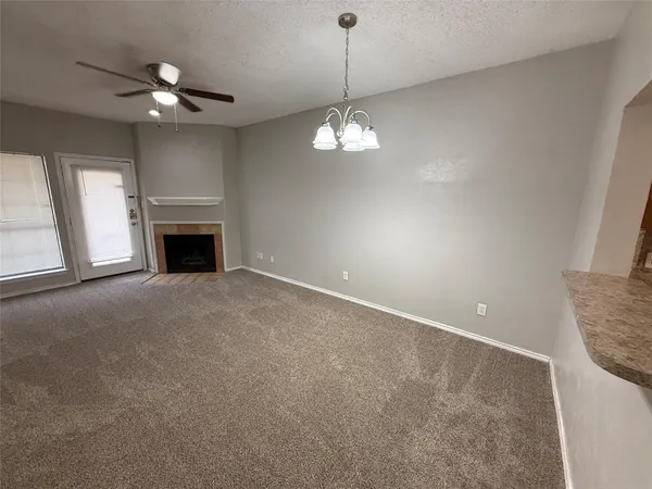 a view of livingroom chandelier fan and fire place