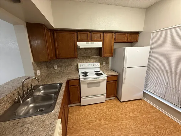a kitchen with a sink a stove and refrigerator