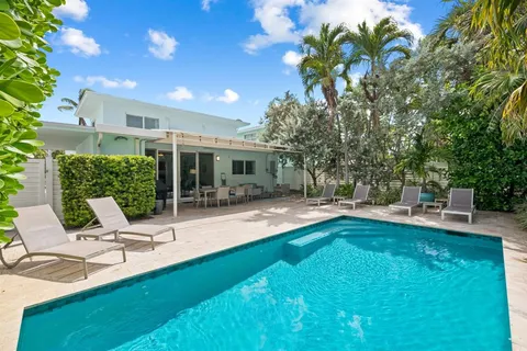 a view of a house with swimming pool and sitting area
