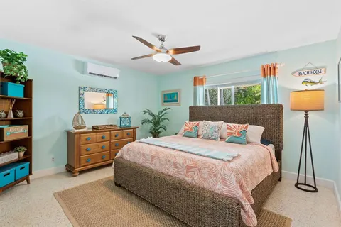 a bedroom with a bed and dresser with mirror