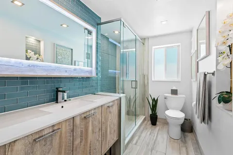 a bathroom with a sink a toilet and shower