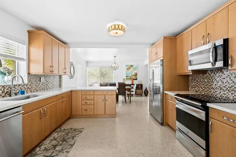 a kitchen with stainless steel appliances granite countertop a stove a sink and a microwave