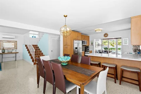 a dining room with furniture a chandelier and wooden floor