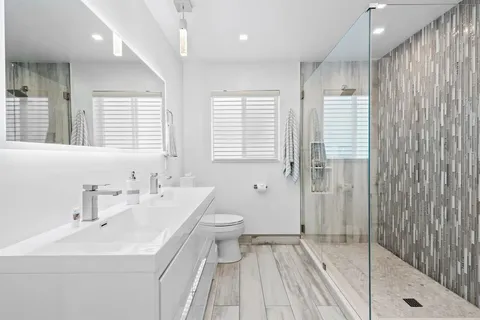 a bathroom with a sink a toilet and shower