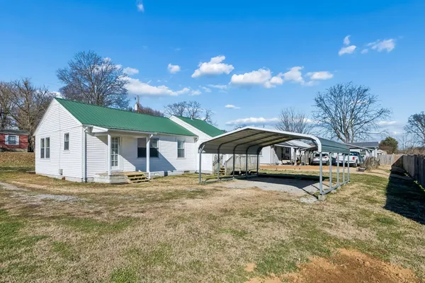 a view of a house with a yard and sitting area
