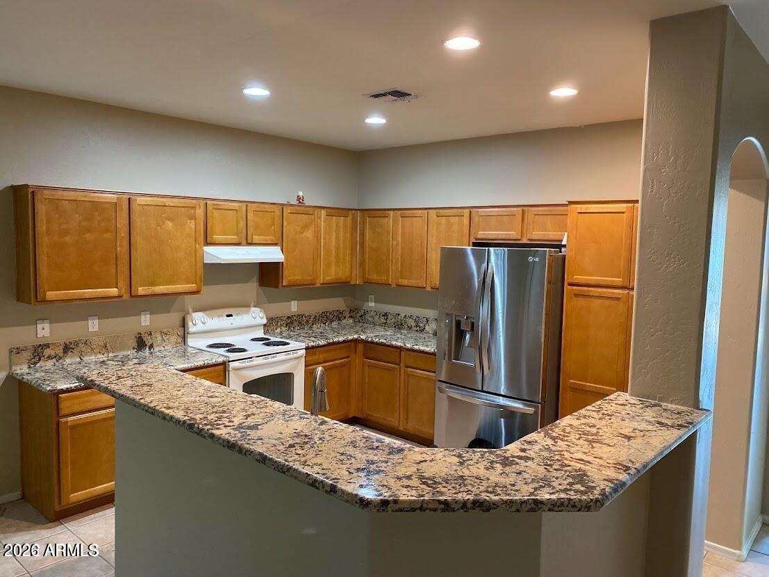 3095 East Merlot Street Gilbert, AZ 85298 - Photo 13 of 13 a kitchen with granite countertop a sink stove and refrigerator