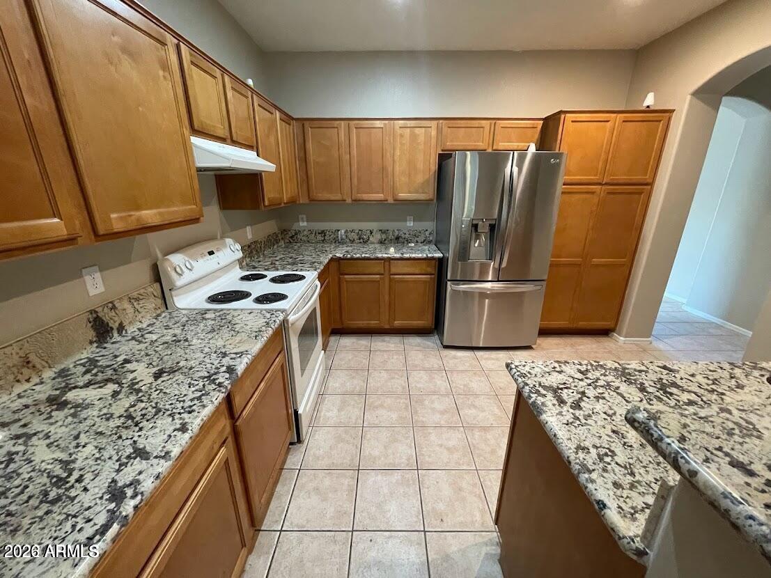 3095 East Merlot Street Gilbert, AZ 85298 - Photo 8 of 13 a kitchen with a stove a refrigerator and a sink