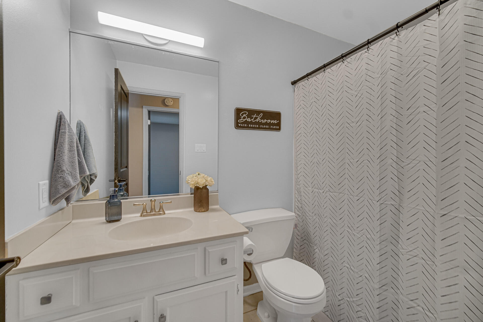 4942 West 93rd Court Crown Point, IN 46307 - Photo 12 of 37 a bathroom with a toilet a sink and mirror