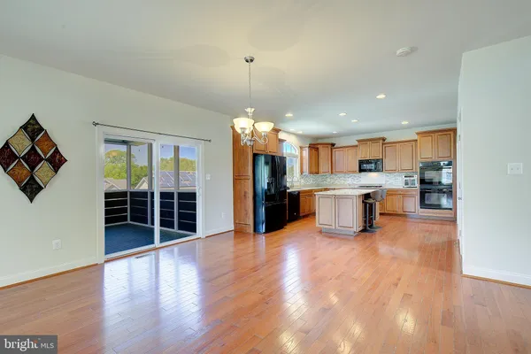 a view of a room with wooden floor chandelier and windows