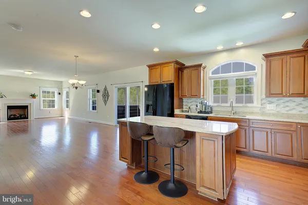 a large kitchen with granite countertop a sink stainless steel appliances and cabinets