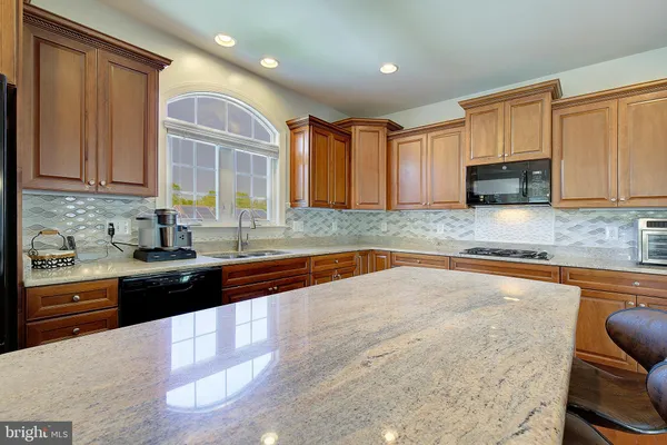 a view of a kitchen with granite countertop stainless steel appliances and wooden floor