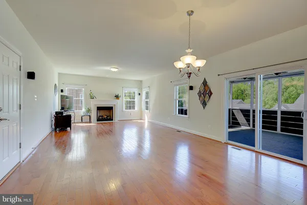 a view of a livingroom with wooden floor a fireplace and window