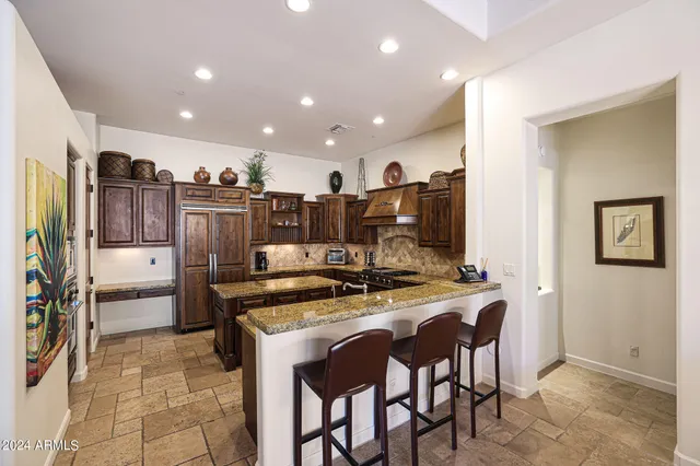 a kitchen with granite countertop a sink stove and refrigerator