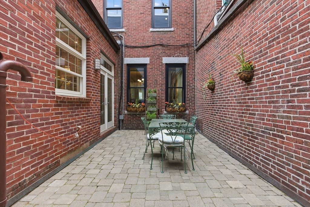 419 Main Street Boston, MA 02129 - Photo 35 of 41 a view of a brick building with chairs and table in a patio