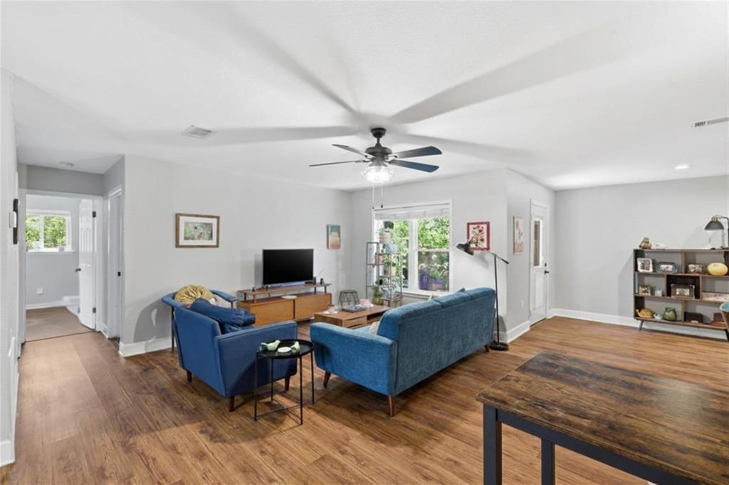 16 Coffee Tavern Road Bedford, TX 76022 - Photo 6 of 24 Spacious living area featuring wood-finish flooring, light gray walls, a ceiling fan, and ample natural light from a large window